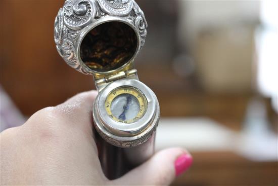 A Victorian walking stick with embossed silver pommel H.M., Birmingham 1906, opens to reveal a compass, overall length 89.5cm